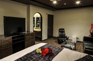a bedroom with a bed and a flat screen tv at Hotel Grande (Love Hotel) in Kitakyushu +6 photos