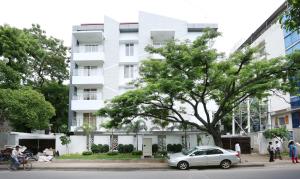un'auto parcheggiata di fronte a un edificio bianco di Treebo Pechis Castle a Chennai