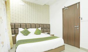 um quarto com uma cama grande e almofadas verdes em Treebo Trend Pechis Castle em Chennai