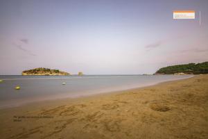 an empty beach with an island in the distance at Hotel Portonuovo in Vieste