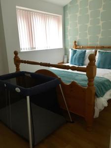 a bedroom with a wooden bed and a window at Valletta House Holiday Apartments in Skegness