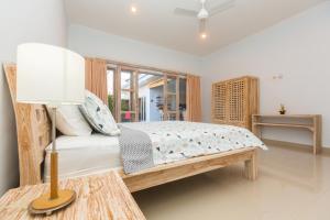 ein Schlafzimmer mit einem Bett und einer Lampe auf einem Tisch in der Unterkunft Castro Villa in Seminyak + 23 Fotos