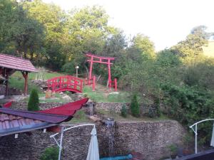 einen Garten mit einem roten Tor und einem Spielplatz in der Unterkunft Casa Lily - Japanese Retreat in Sighişoara