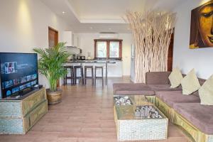 a living room with a couch and a table at Tropical Season Villa Resort in Mae Nam