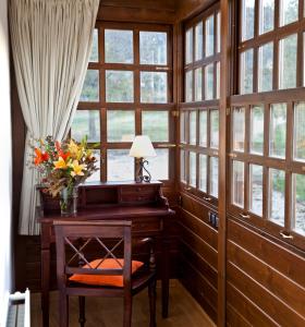 a room with a desk with a vase of flowers at Hotel Casona Cuervo in San Tirso de Candamo +44 photos