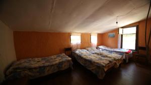 a room with three beds in a room at Korsha Guesthouse in Roshka