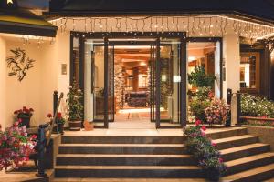 einen vorderen Eingang zu einem Haus mit Treppen und Blumen in der Unterkunft Hotel Haymon in Seefeld in Tirol