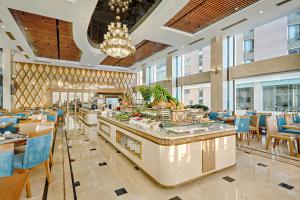 a restaurant with tables and chairs and a buffet at Paris Deli Danang Beach Hotel in Danang