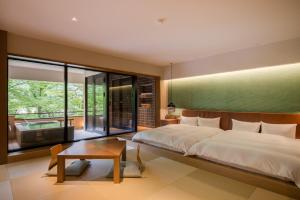 1 dormitorio con 1 cama grande y 1 mesa en Sekizenkan Kashotei Sanso en Nakanojo