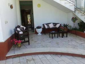 un patio con divano, sedie e scale di Villa Margherita a Mazara del Vallo