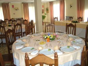 une salle à manger avec une table, des nappes blanches et des chaises dans l'établissement Hotel Río Piscina, à Priego de Córdoba