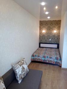 キーロフにあるVD Apartmentsの小さなベッドルーム(ベッド1台、ソファ付)