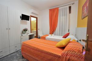 a hotel room with two beds and a television at B&B Cornelia in Pompei