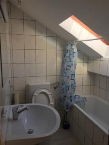 a bathroom with a sink and a toilet and a tub at Gasthof Rössle Ochsenwang in Bissingen an der Teck