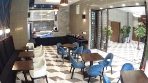 釜山的住宿－Stanford Hotel Busan，餐厅设有木桌和蓝色椅子