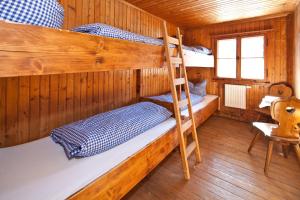 a room with three bunk beds in a cabin at Wannenkopfhütte in Obermaiselstein