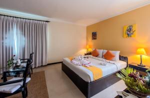 a bedroom with a bed and a desk and a chair at Angkor Panoramic Boutique Hotel in Siem Reap