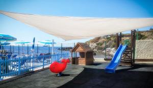 a playground with a slide and a play structure at Hotel Rex in Livorno
