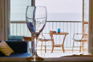 ein Weinglas auf einem Tisch auf einem Balkon in der Unterkunft Relax and sun in Santa Pola