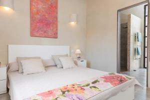 a bedroom with a white bed with a flower blanket on it at Can Pina - Eco Cascada - in Costitx +37 photos