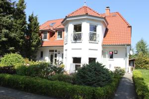 a white house with a red roof at Feriendomizil am Hafen in Zingst