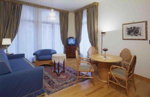 a living room with a blue couch and a table and chairs at San Marco Palace in Venice