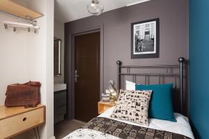 a bedroom with a bed with a blue wall at Peckham Rooms Hotel in London