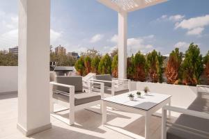 un patio con sillas blancas y una mesa en el techo en Casa Los Pacos, en Fuengirola