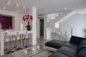 a living room with a couch and a bar with stools at Casa Los Pacos in Fuengirola