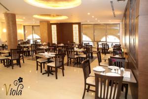 a dining room with tables and chairs in a restaurant at Viola Hotel Suites in Amman