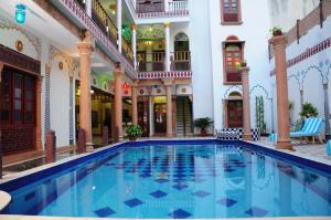 a large swimming pool in a building with columns at Hotel Vimal Heritage in Jaipur