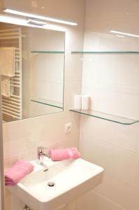 een witte badkamer met een wastafel en een spiegel bij Ferienwohnung Fiel in Sankt Gallenkirch +36 foto's