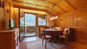 een eetkamer met een tafel met stoelen en een televisie bij Ferienwohnung Fiel in Sankt Gallenkirch