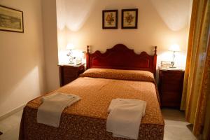 a bedroom with a bed with two towels on it at Pensión San Benito Abad in Seville