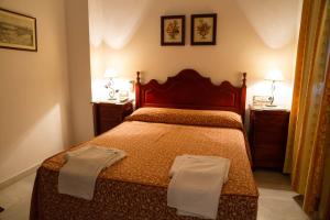 a bedroom with a bed with two towels on it at Pensión San Benito Abad in Seville
