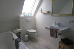 uma casa de banho com um lavatório, WC e um espelho. em Ferienhaus Richard em Husum