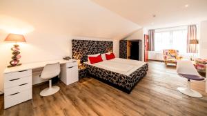 a bedroom with a bed and a desk and chairs at artHOTEL Magdeburg in Magdeburg
