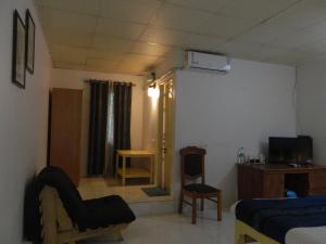 Habitación con 1 dormitorio con 1 cama y TV. en Fantasy Golf Resort, en Devanhalli