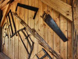 a group of tools hanging on a wooden wall at Holiday Home near the forest in Rendeux