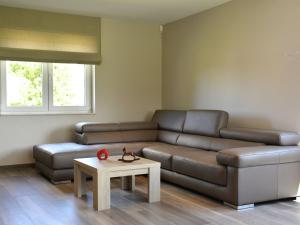 uma sala de estar com um sofá castanho e uma mesa em Modern villa in Rochefort close to the horses em Wavrielle