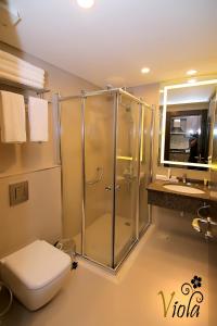uma casa de banho com um chuveiro, um WC e um lavatório. em Viola Hotel Suites em Amã