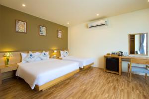 a hotel room with a bed and a desk and a bed at GAIA Hotel & Residence Phu Quoc in Phú Quốc +33 photos
