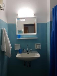 a blue bathroom with a sink and a mirror at Paradise Garden in Piso Livadi