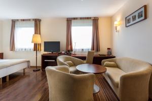 a hotel room with chairs and a bed and a table at Qubus Hotel Gliwice in Gliwice