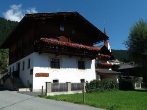 Casa blanca con flores rojas en el balcón en Haus Antonius, en Sankt Lorenzen im Lesachtal
