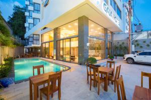 a hotel with a swimming pool and tables and chairs at Gaia Hotel Phu Quoc in Phú Quốc