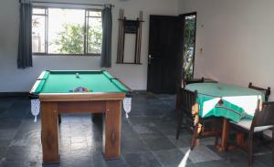 une chambre avec un billard et deux chaises dans l'établissement Pousada Nayane, à Barequeçaba