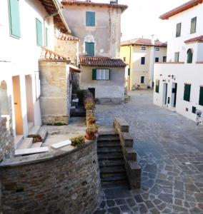 a courtyard of a building with a stone wall and stairs at Casa Pastoricchio in Grado