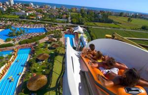 a group of people riding a roller coaster at a water park at Hotel Verdi in Lido di Jesolo