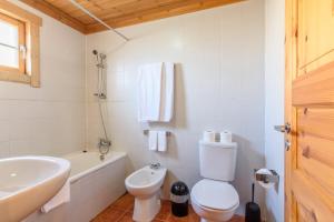 um banheiro branco com um vaso sanitrio e uma pia em Luna Chalets da Montanha - Serra da Estrela na Covilh